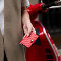 Secrid Miniwallet Emboss Diamond│art. MED-RED│in hand van vrouw voor rode scooter