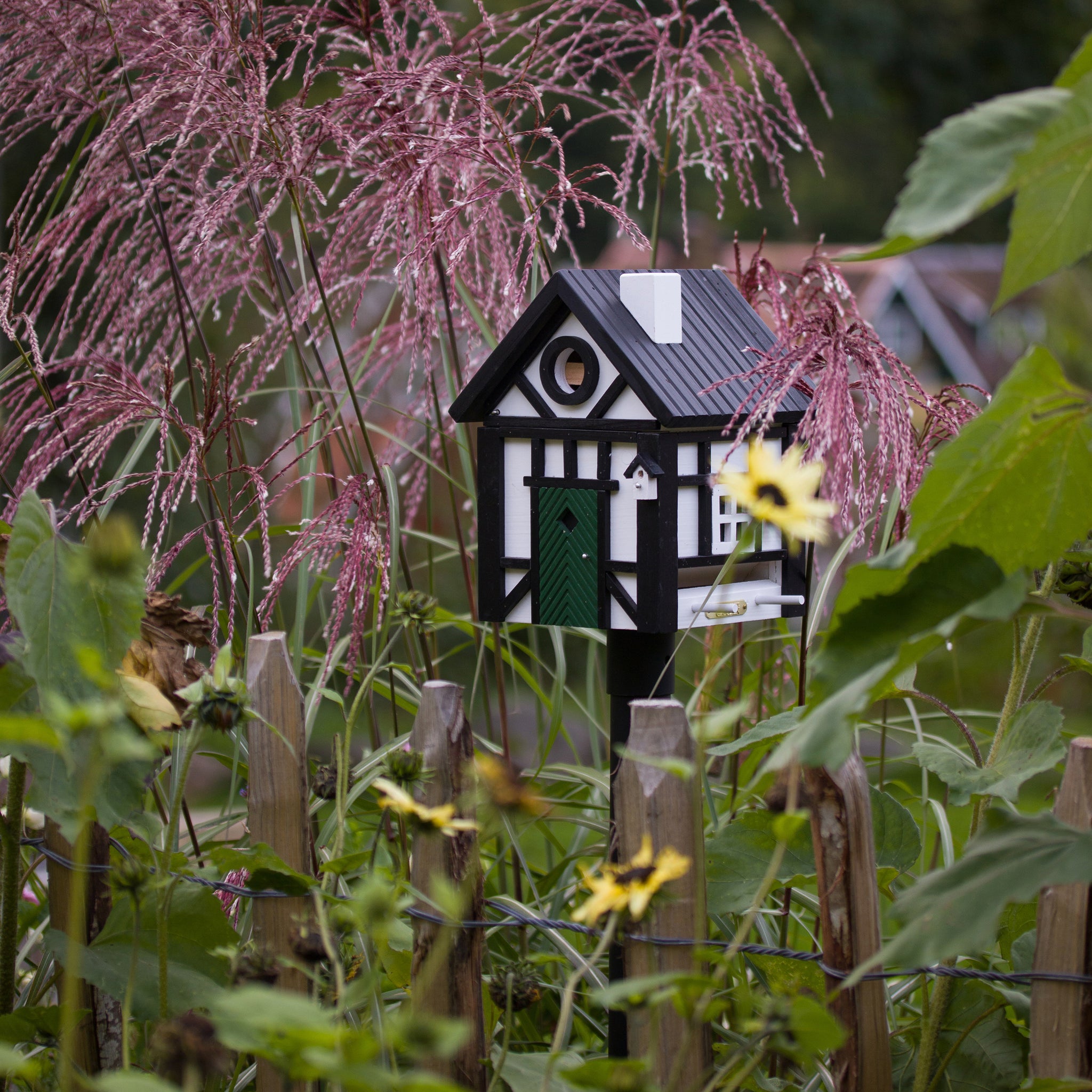 Multiholk Vakwerkhuis Vogelhuis│Wildlife Garden│art. WG109│op metalen paal naast bloemen en planten