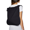 Woman wears black Notabag as a backpack