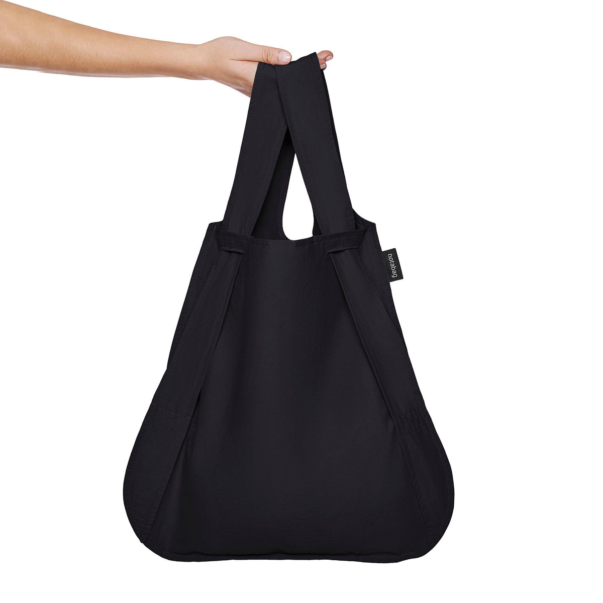 Black Notabag as a shopper bag held in the hand