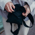 Black Notabag folded up, held in the hand