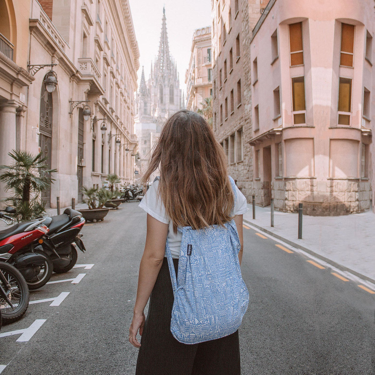 Vrouw draagt Notabag Hello World Raw Blue rugzak op straat