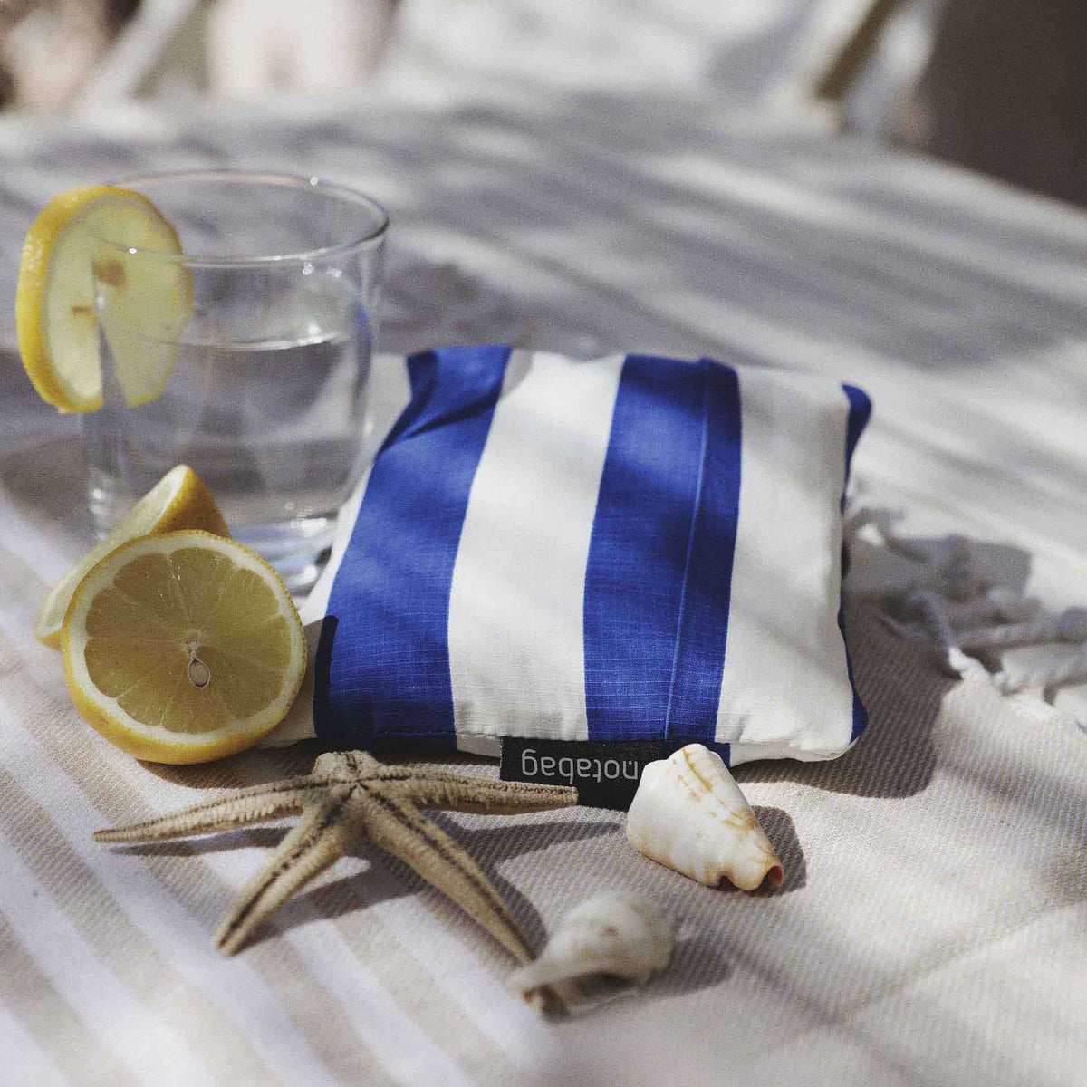 Notabag Marine Stripes opgevouwen op een buitentafel