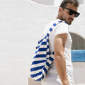 Man draagt Notabag Marine Stripes rugzak voor een wit gebouw