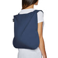 Woman wears navy blue Notabag backpack