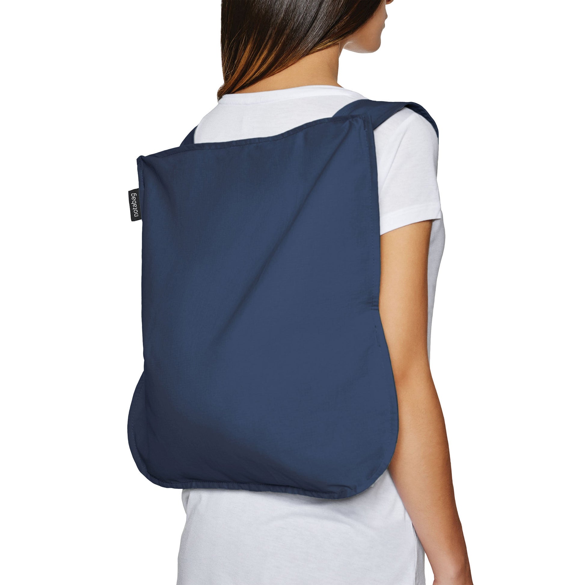 Woman wears navy blue Notabag backpack