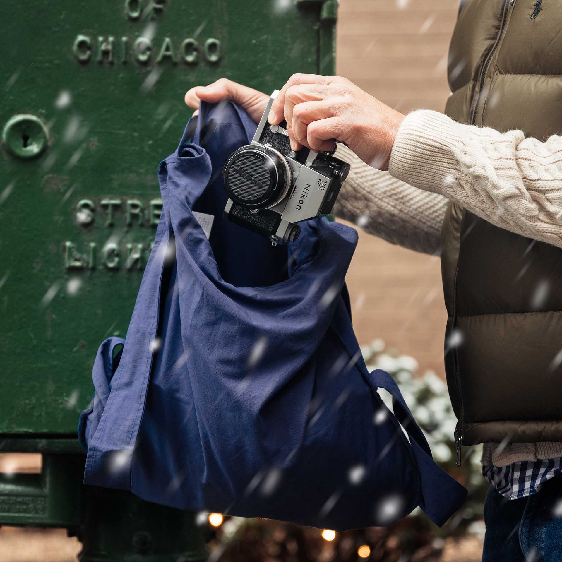Man puts a camera into navy blue Notabag