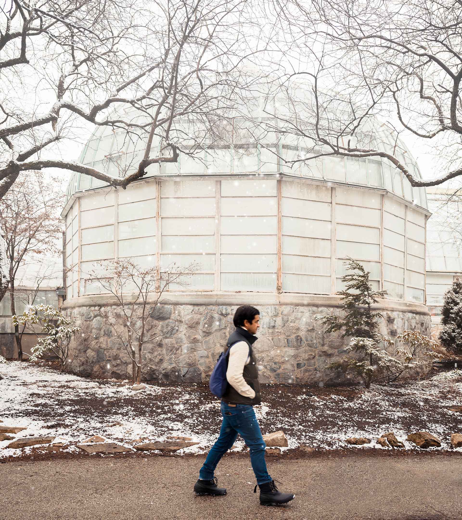 Man with navy blue Notabag backpack in front of a round building