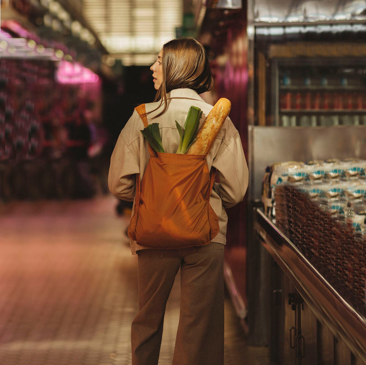 Vrouw draagt Notabag Recycled Mosterd Geel rugzak met boodschappen