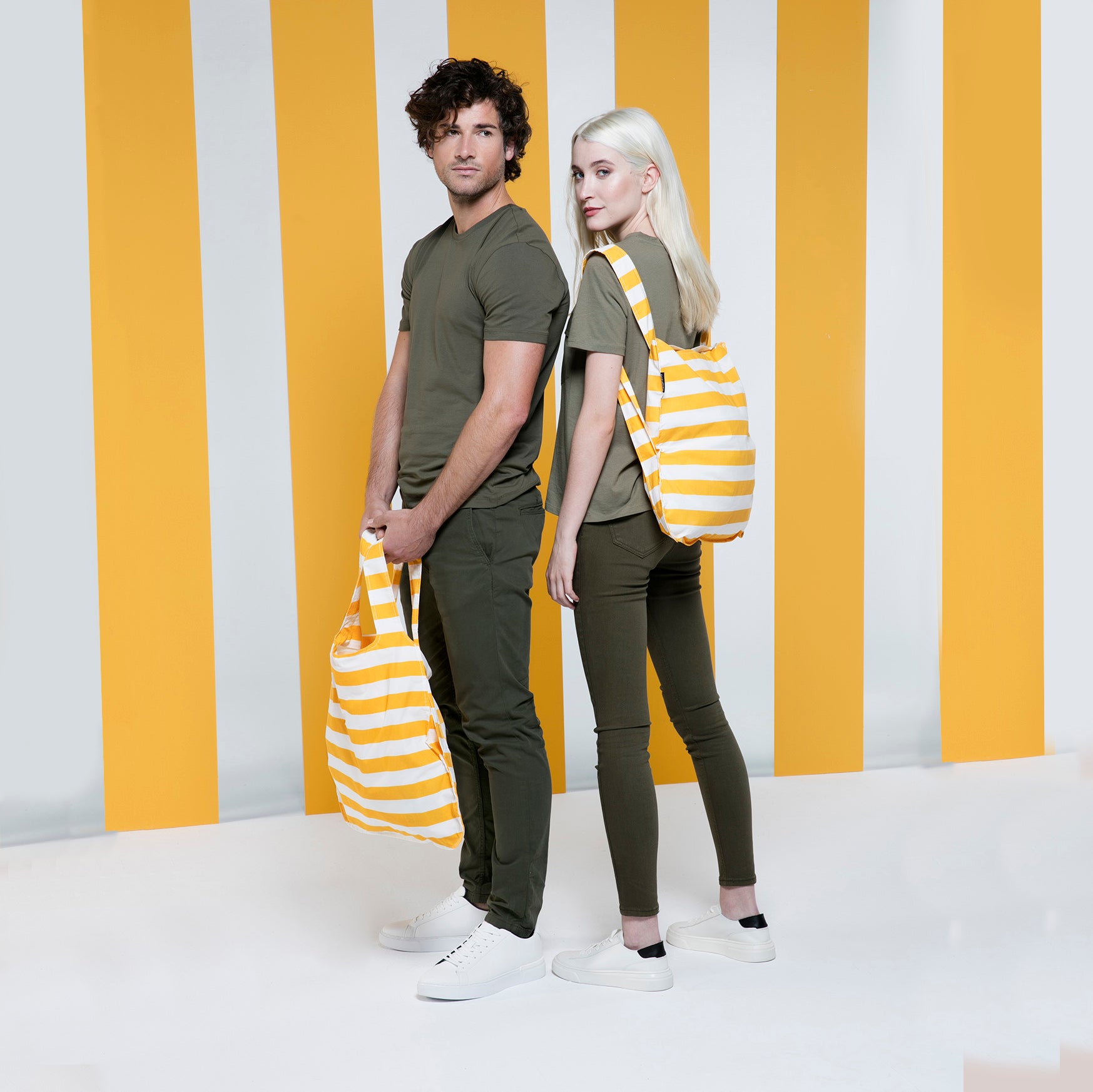 Notabag Golden Stripes│art. NB-P-GST5│man met shopper en vrouw met rugzak voor geel/witte achtergrond
