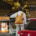 Vrouw met stokbrood in Notabag Recycled Mosterd Geel rugzak