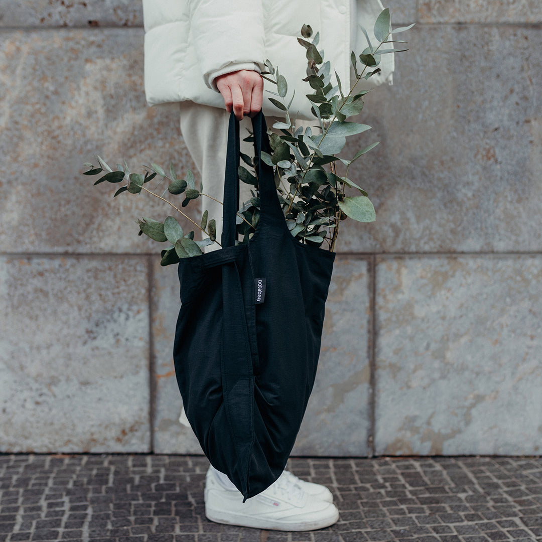 Black Notabag held with plants inside