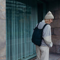Woman with black Notabag backpack in front of a window