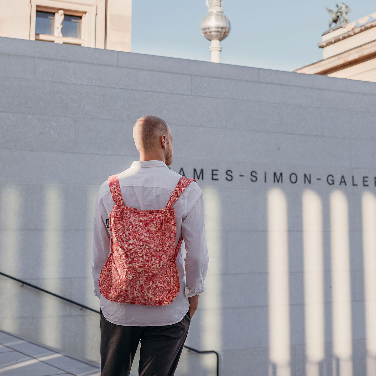 Man draagt Notabag Hello World Rose Red rugzak buiten