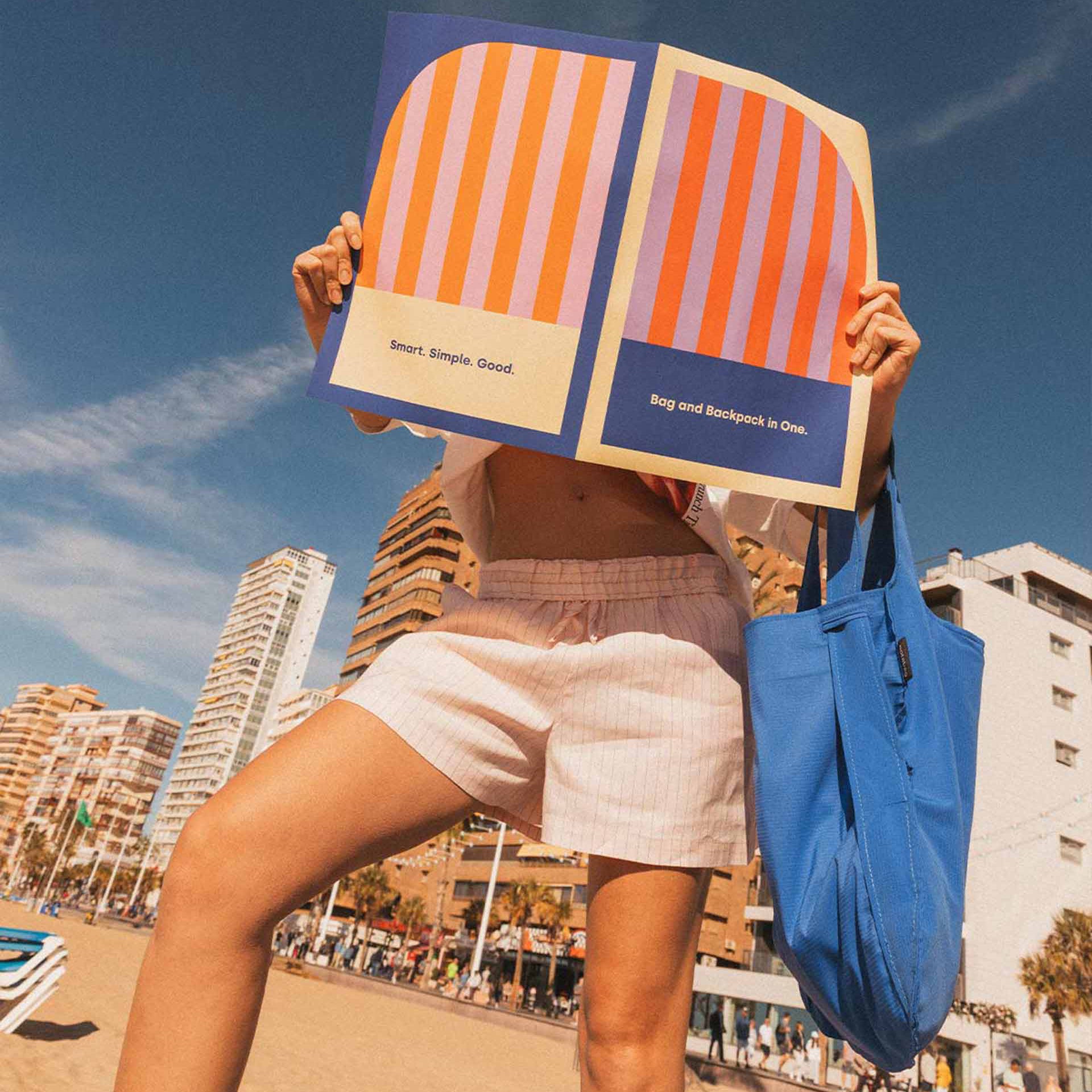 Notabag Royal Blue über dem Unterarm einer Frau am Strand