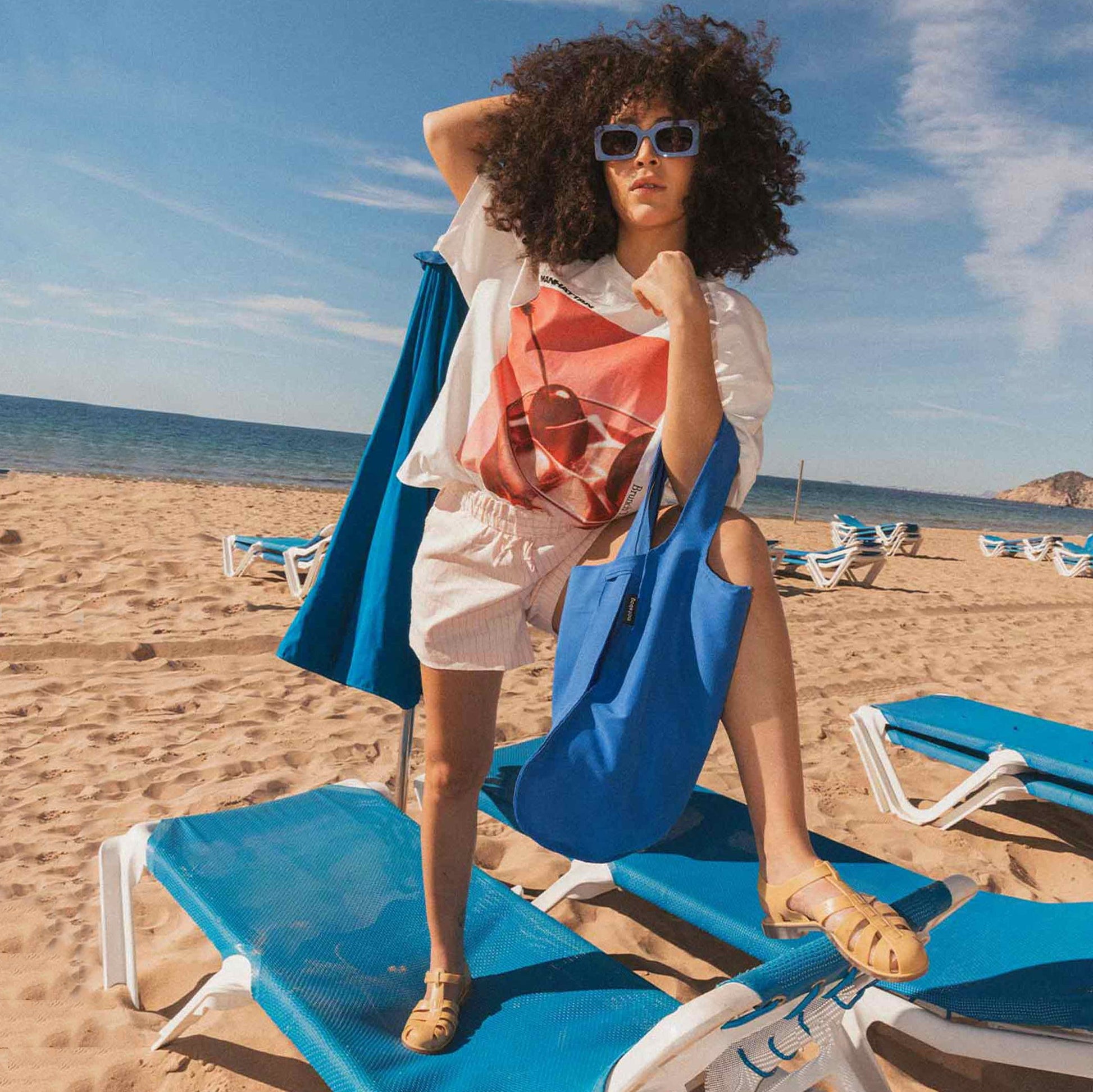 Frau auf einem Strandstuhl mit Notabag Royal Blue Shopper-Tasche