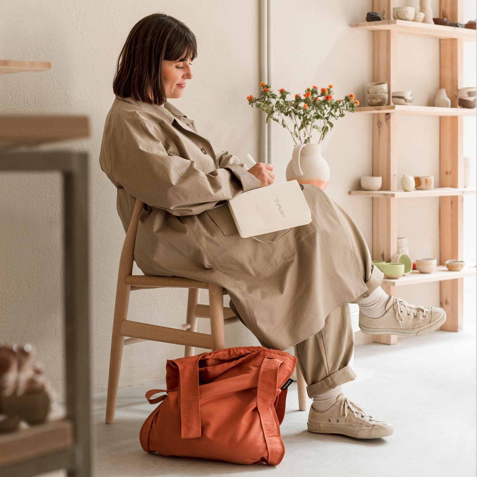 Woman with Notabag Terracotta shopper bag next to a chair