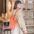 Woman with Notabag Terracotta backpack in a shop with ceramics