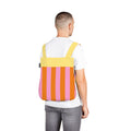Man wears Notabag Vanilla Stripes backpack against a white background