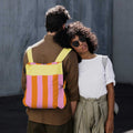 Man wears Notabag Vanilla Stripes backpack with a woman beside him