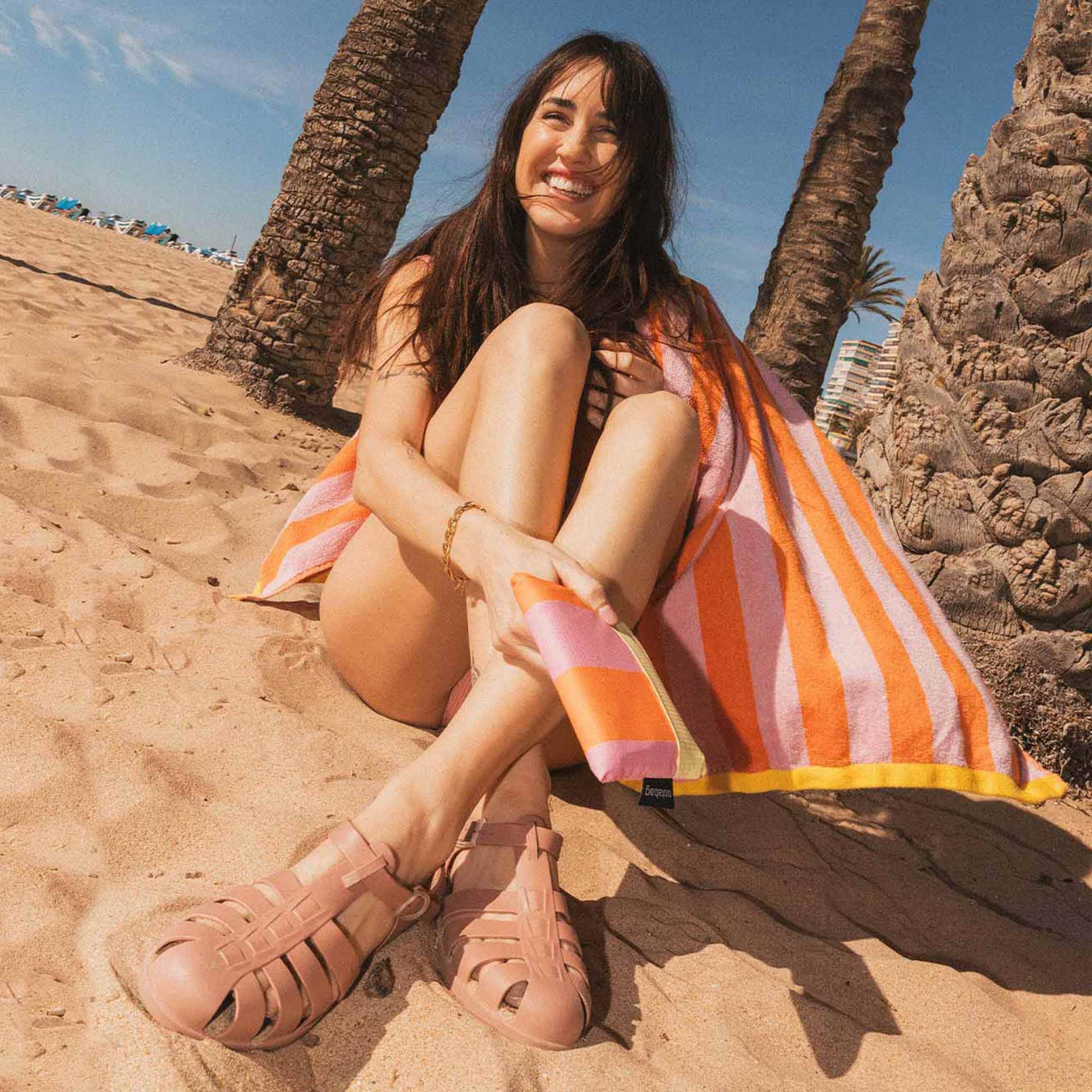 Woman on the beach with folded Notabag Vanilla Stripes