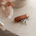 Orbitkey Pebbled Leather Amber│Sleutelhouder│art. KPB2-AMB-101│op stenen tafel met uitgevouwen sleutels