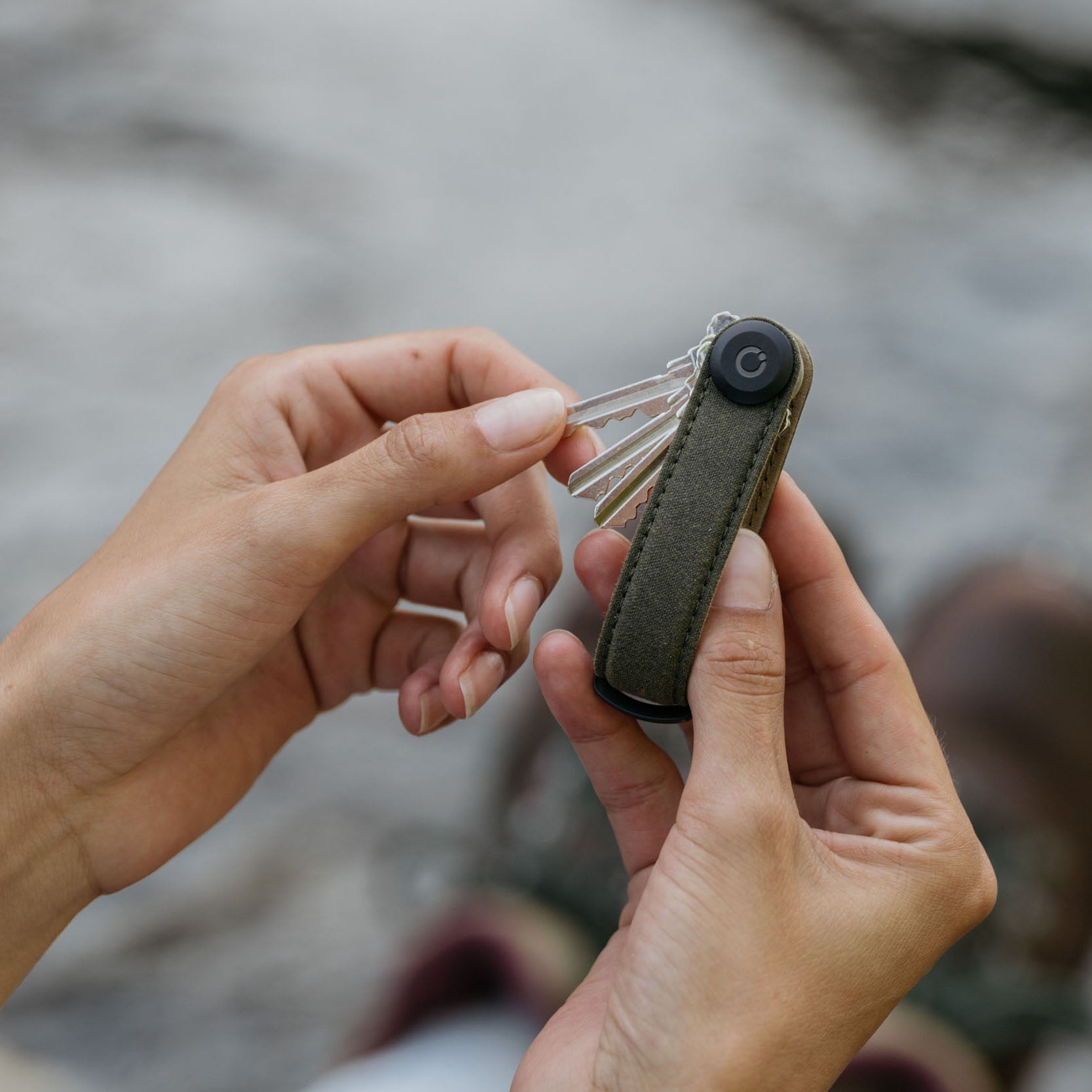 Orbitkey Waxed Canvas Sleutelhouder Khaki Green│art. KWC2-KGN-107│in hand van vrouw met sleutels