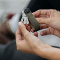 Orbitkey Waxed Canvas Sleutelhouder Khaki Green│art. KWC2-KGN-107│uitgevouwen sleutels in hand van vrouw