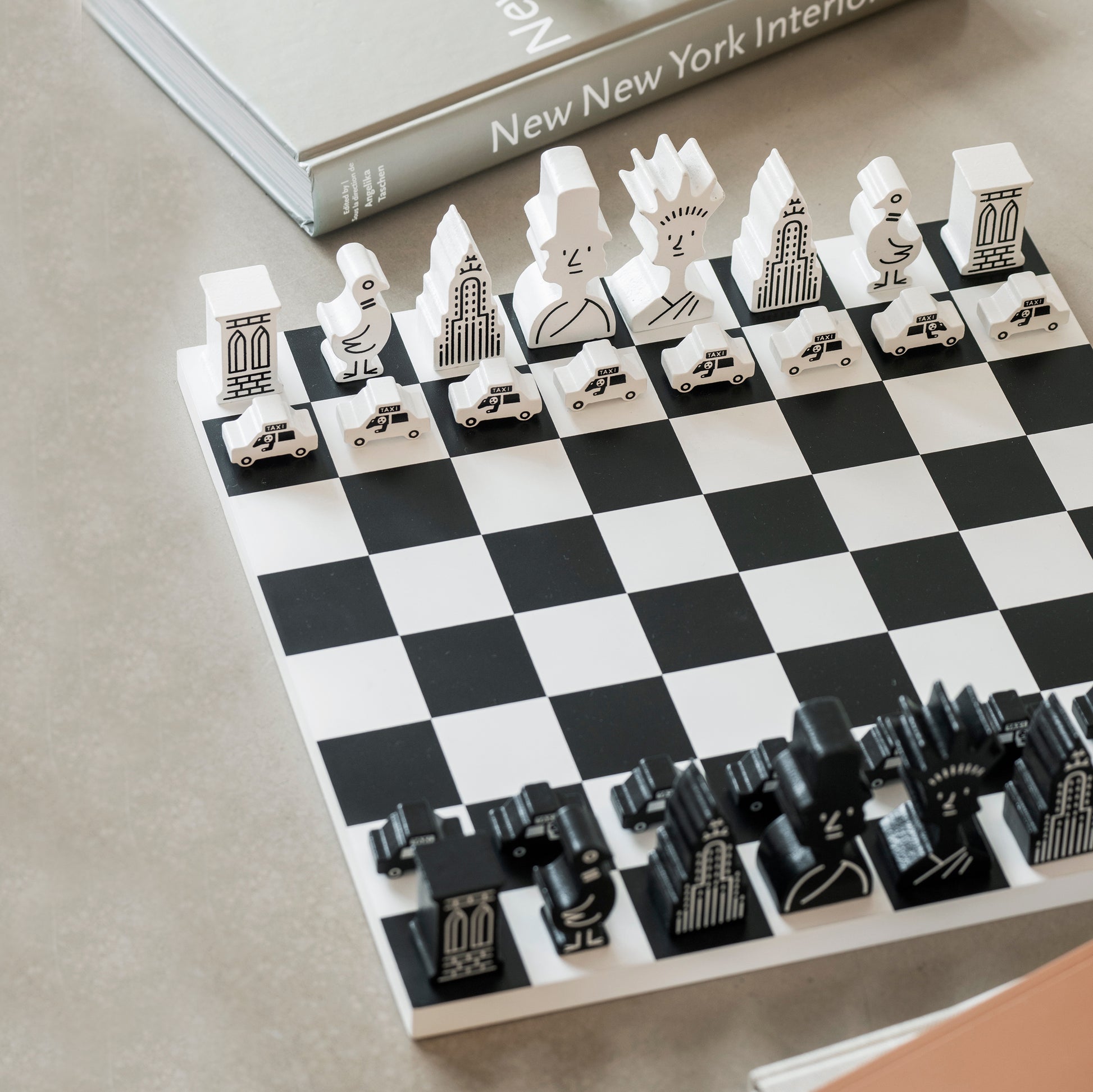 Schaakspel Chess NYC│The New Yorker x Printworks│art. PW00720│met schaakstukken op tafel naast boeken