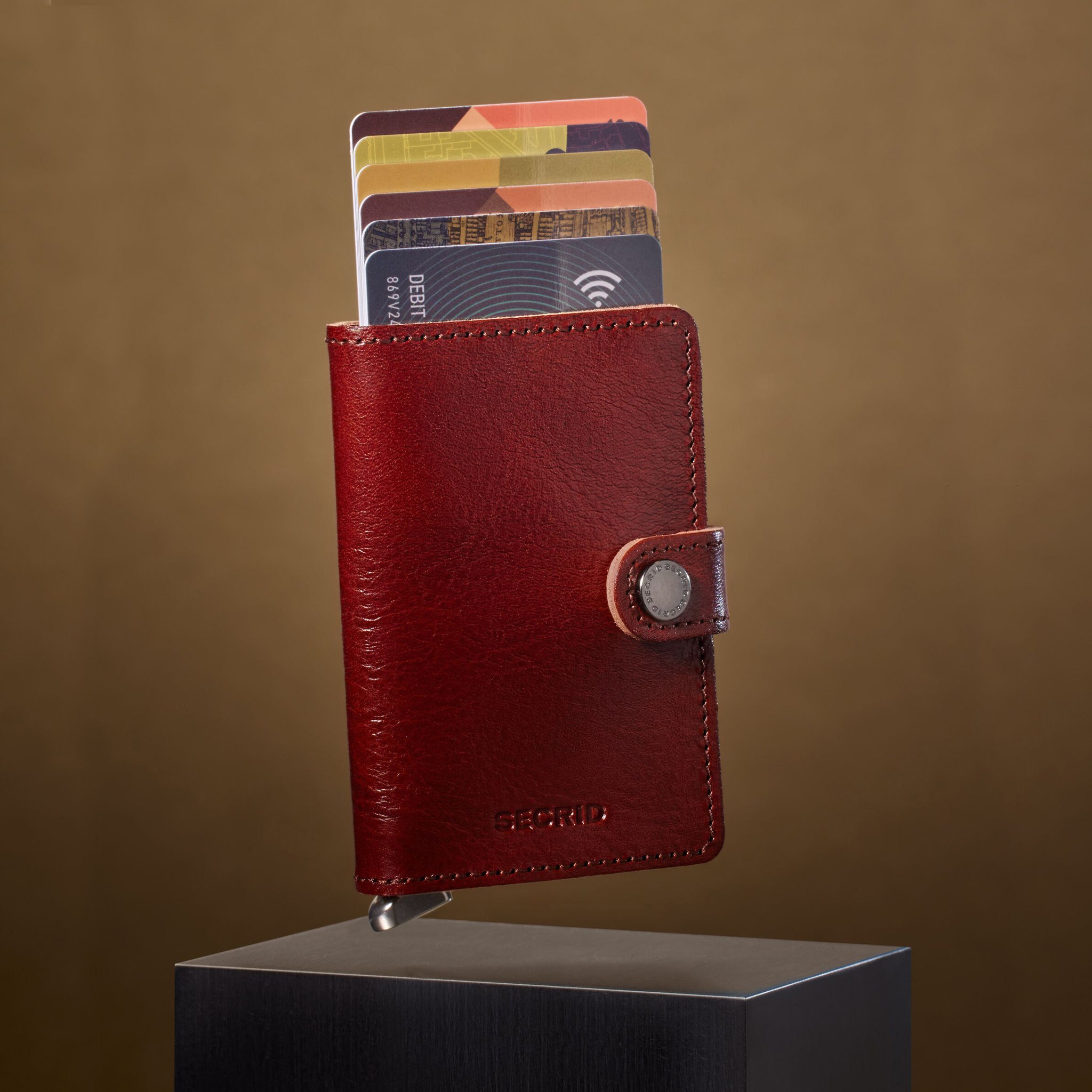 Secrid Miniwallet Premium Basco Brown│Pasjeshouder│art. MBC-BROWN│zwevend boven blok met beige achtergrond