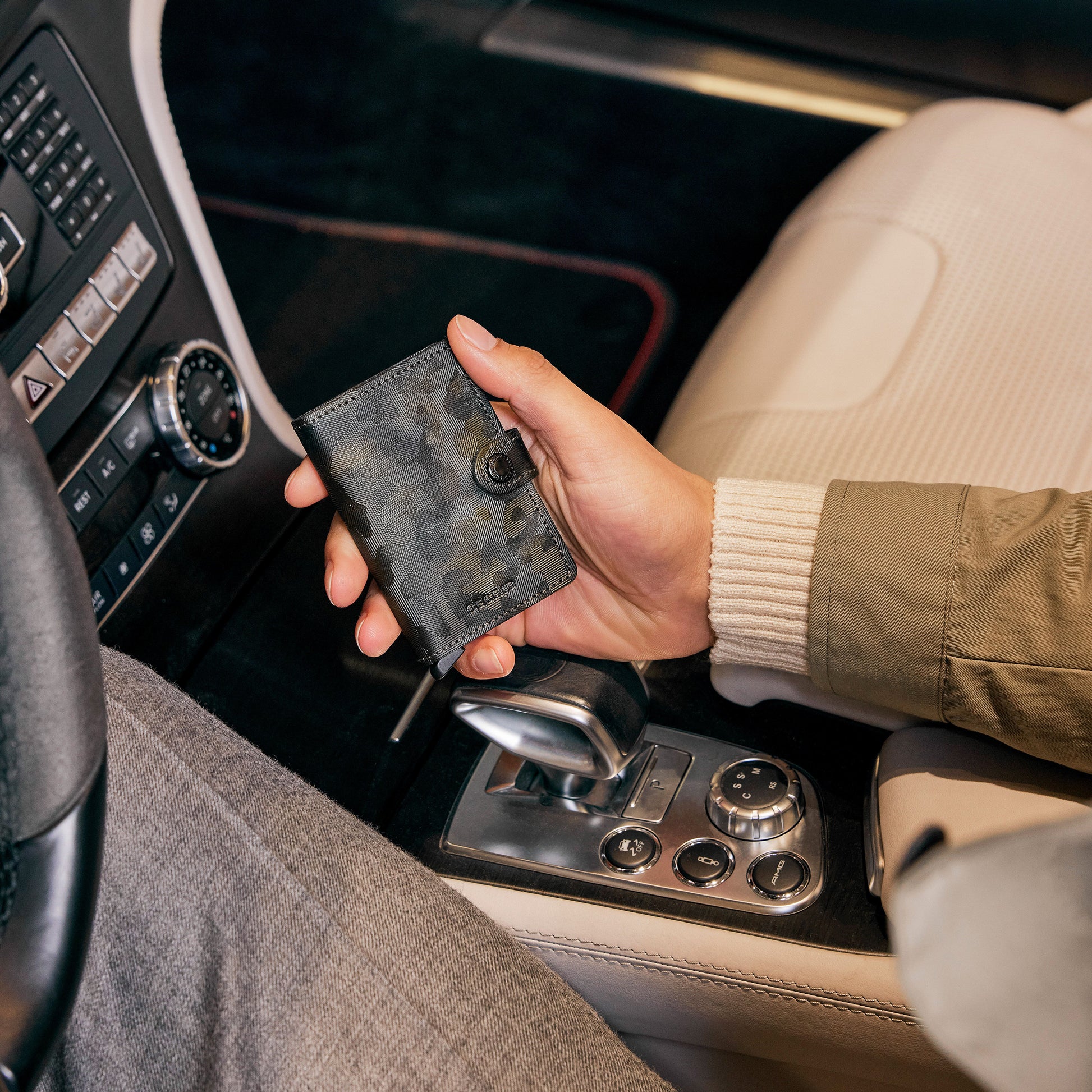 Secrid Miniwallet Jungle│art. MJU-MOSS│man houdt portemonnee vast in auto