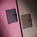 Secrid Miniwallet Matte│art. MM-DARKPURPLE&FUCHSIA│naast truffel versie op gekleurde ondergrond