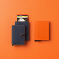 Secrid Miniwallet Matte│Pasjeshouder en Portemonnee│art. MM-NIGHTBLUE&ORANGE│met slimwallet en cardprotector op oranje ondergrond