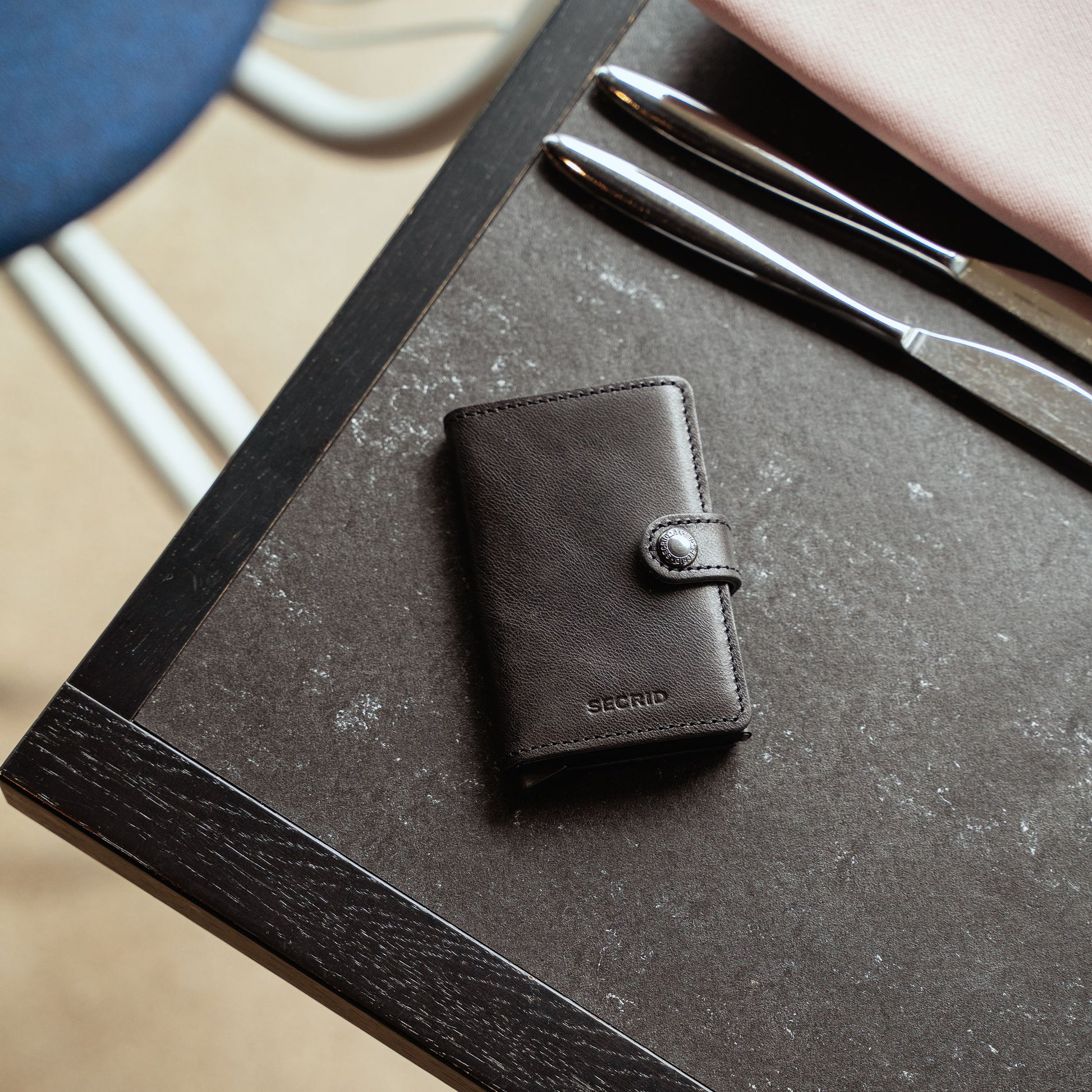 Secrid Miniwallet Vintage Zwart│art. MV-BLACK│Pasjeshouder en Portemonnee│bovenaanzicht op tafel in restaurant