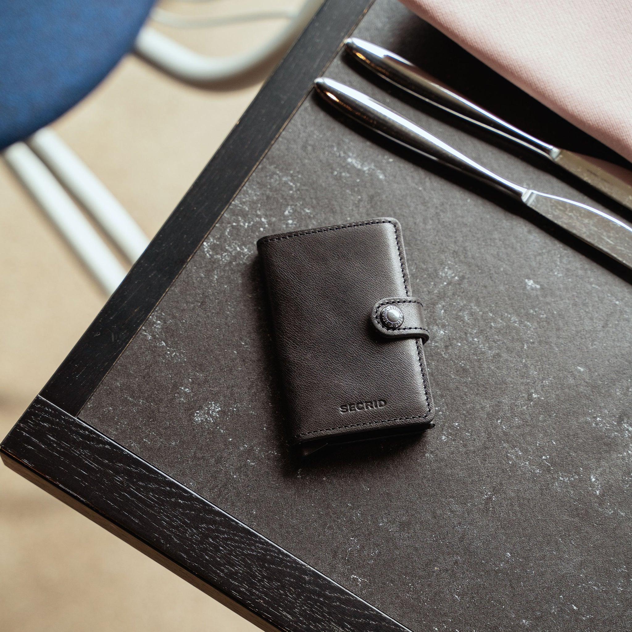 Secrid Miniwallet Vintage Zwart│art. MV-BLACK│Pasjeshouder en Portemonnee│bovenaanzicht op tafel in restaurant