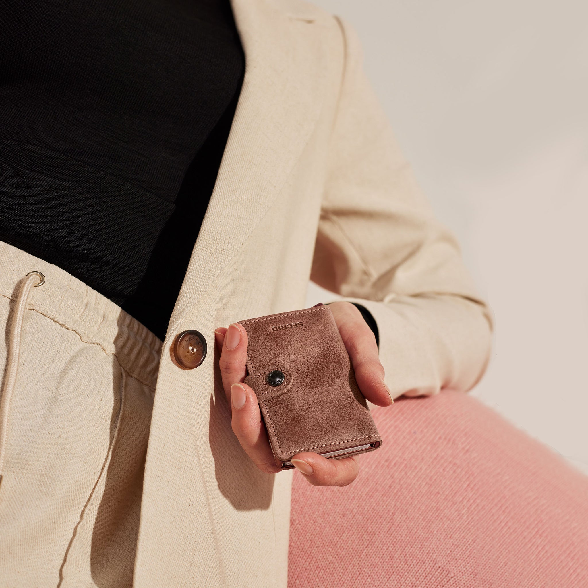 Secrid Miniwallet Vintage│art. MV-TAUPE│Pasjeshouder en Portemonnee│in hand van man in beige pak