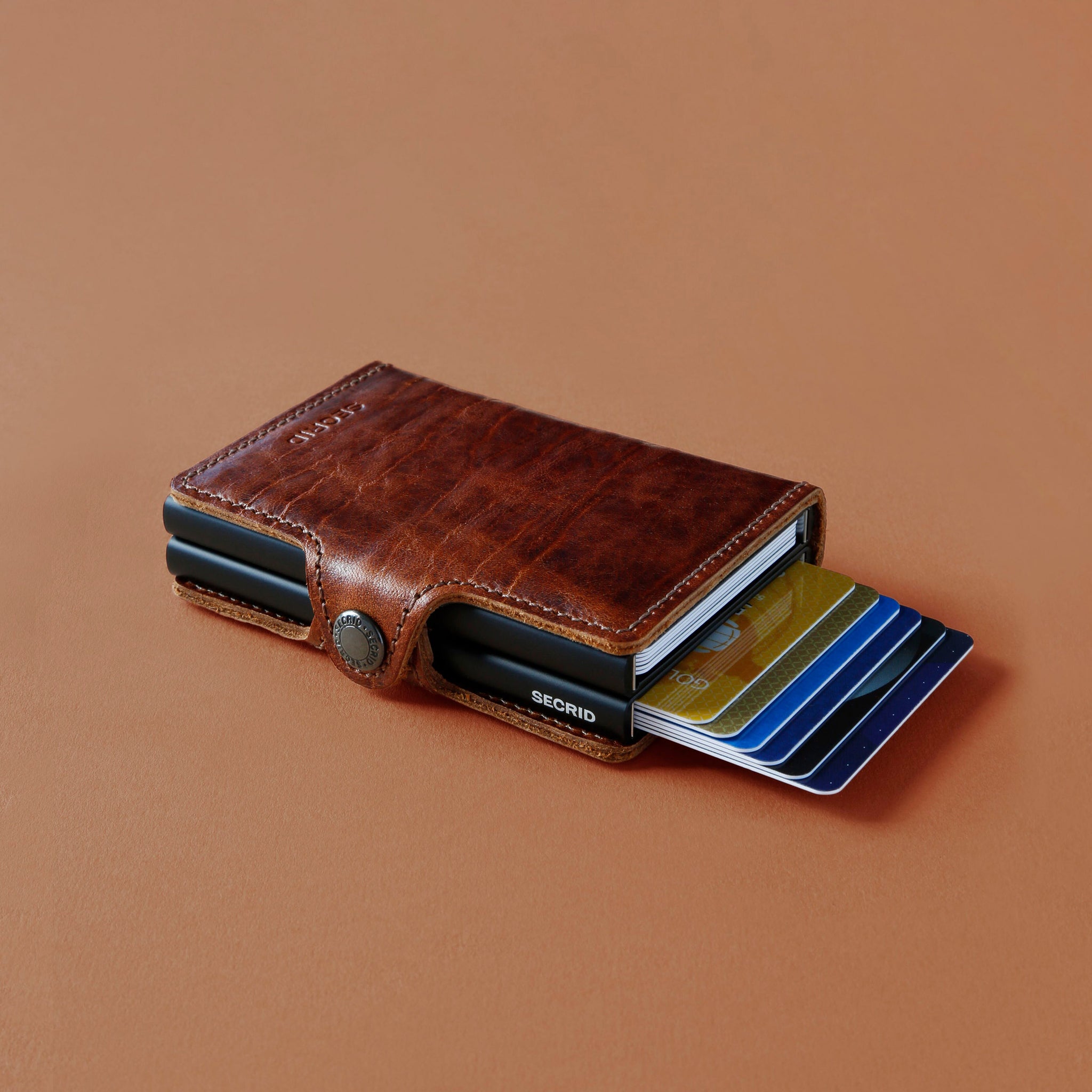 Secrid Twinwallet Dutch Martin│art. TDM-WHISKEY│Pasjeshouder│liggen met pasejs en beige ondergrond