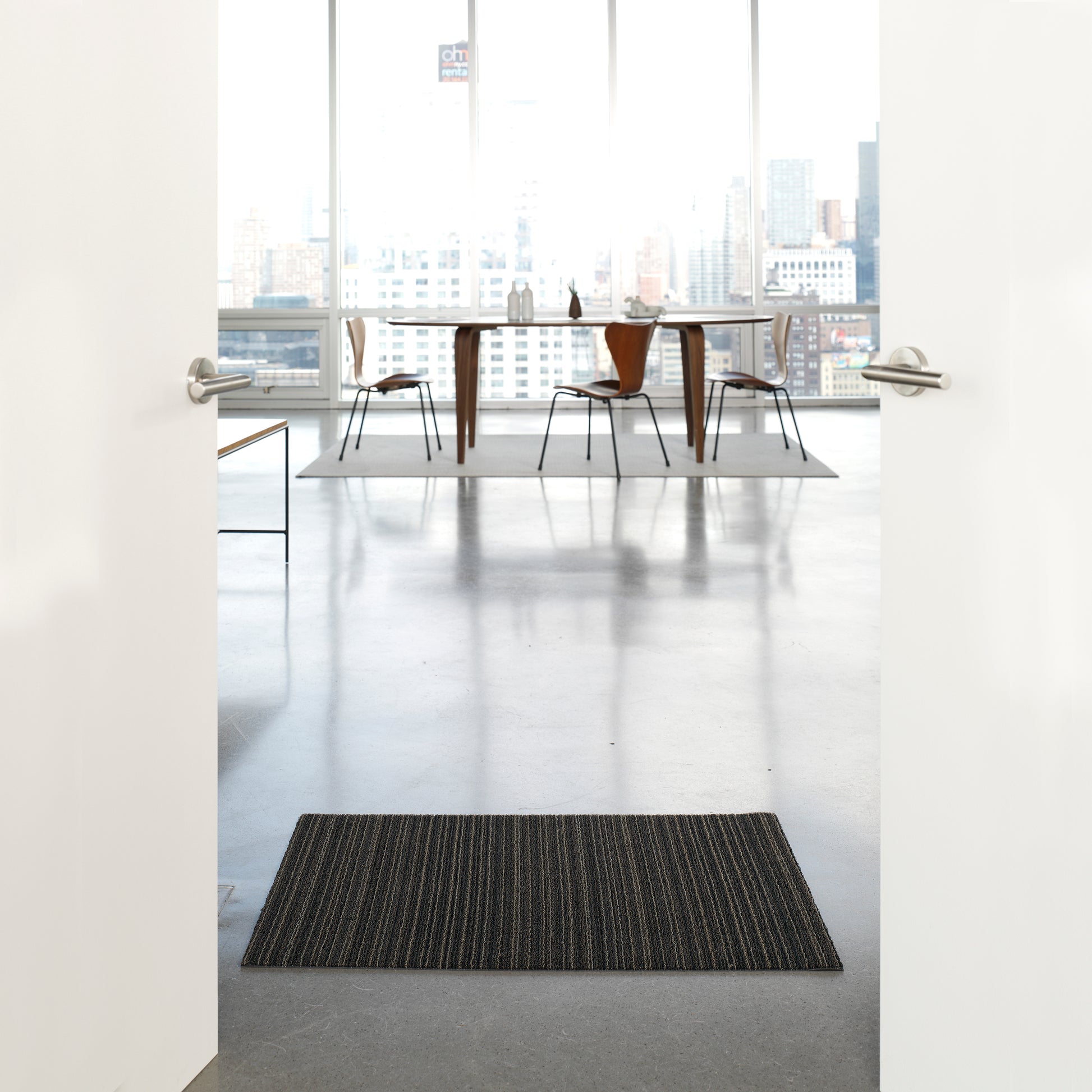 Chilewich Shag Deurmat 46x71 Skinny Stripe Steel│art. 200134-008│in deuropening op betonnen vloer van luxe appartement