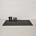 Chilewich Shag Deurmat 46x71 Skinny Stripe Steel│art. 200134-008│met hoge schoenen op houten ondergrond