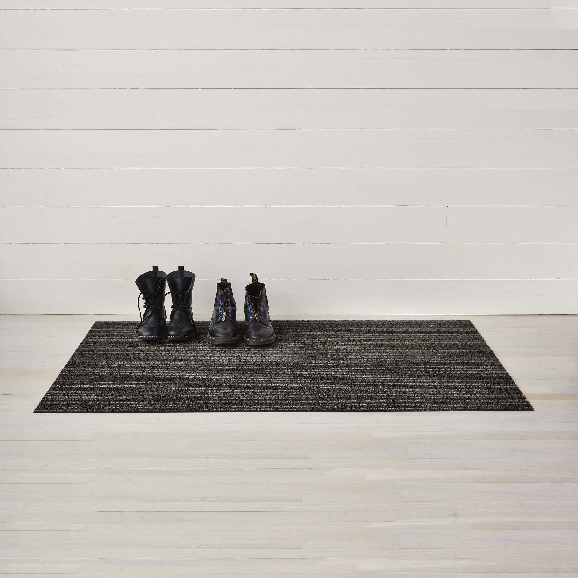 Chilewich Shag Deurmat 46x71 Skinny Stripe Steel│art. 200134-008│met hoge schoenen op houten ondergrond