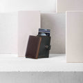 Secrid Slimwallet Original│art. SO-CHOCOLATE│leunend tegen Miniwallet met steenblokken op achtergrond