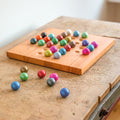 Remember Solitaire Houten Bordspel | art. SOL1 | op een oud houten kastje met enkele ballen naast het bord