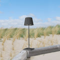 Sompex Troll 2.0 Antraciet│Oplaadbare Tafellamp│Buitenverlichting│art. 78180│op houten hek in duinen