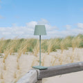 Sompex Troll 2.0 Olijfgroen│Oplaadbare Tafellamp│Buitenverlichting│art. 78174│op houten hek in duinen