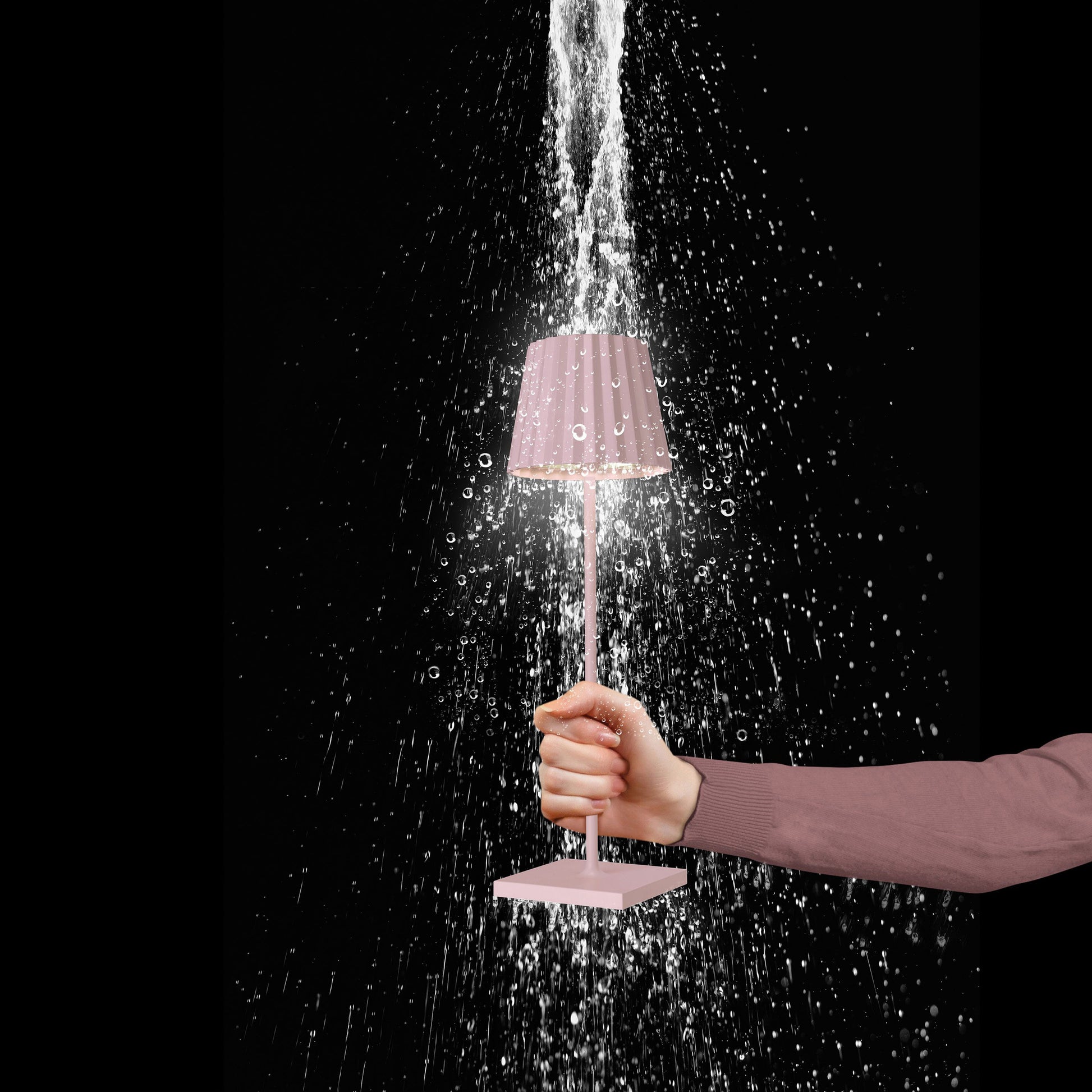 Sompex Troll 2.0 Roze│Oplaadbare tafellamp│Buitenverlichting│art. 78177│in hand onder spatwater