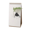 Flip Vase Kat Spextrum - vooraanzicht met een tekening van een zwarte kat op een schutting met een groene tak in het vaasje