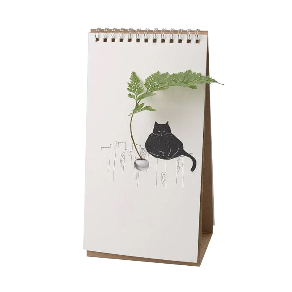 Flip Vase Kat Spextrum - vooraanzicht met een tekening van een zwarte kat op een schutting met een groene tak in het vaasje