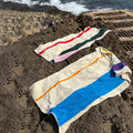 Strandlaken Martens & Martens Aqua Orange Purple & Yellow Suite702│art. CMMTT90AQORPUYE│2 soorten op rotsstrand