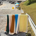 Strandlaken Martens & Martens Red Dark Green Toffee&Pink Suite702│art. CMMTT90REDGTOPI│s soorten over metalen railing aan strand