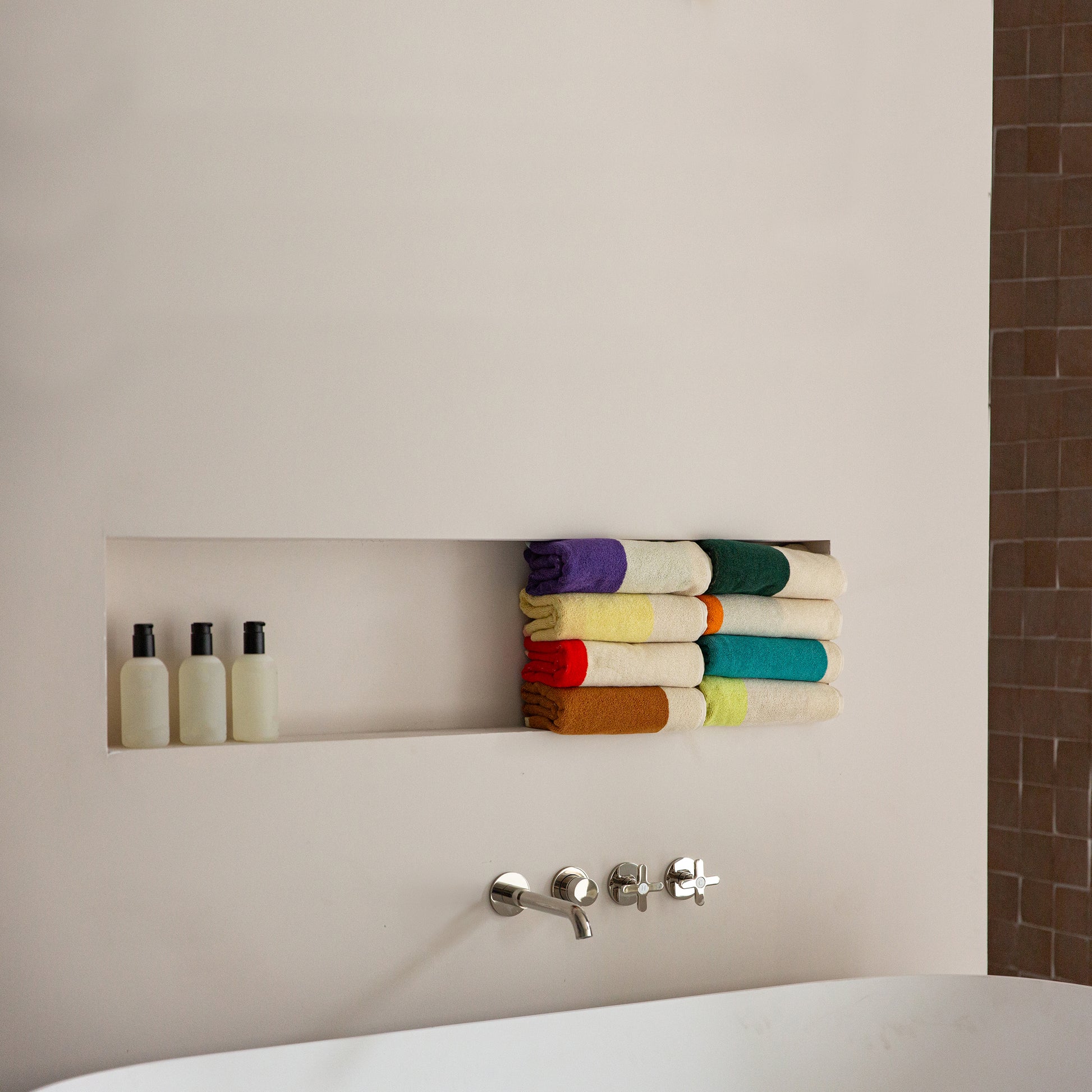 Handdoeken Martens & Martens 50x100 Suite702│alle varianten opgevousen in nis boven badkuip